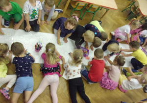 Smyki i Tuptusie na dużym arkuszu papieru kolorują kropki