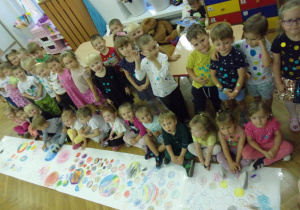Smyki i Tuptusie na dużym arkuszu papieru kolorują kropki