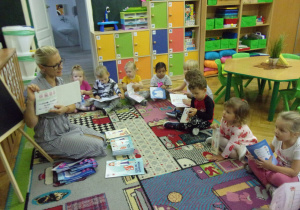 ciocia Aga omawia sposób mycia zębów, dzieci w kole na dywanie