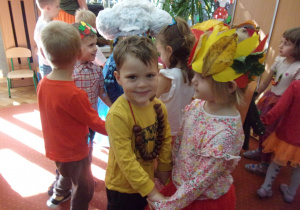 chłopiec tańczy z dziewczynką, oboje przebrani w stroje jesienne