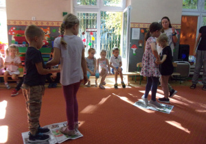 dzieci tańczą w parach na gazetach