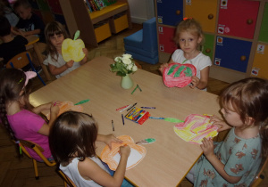 dzieci kolorują sylwety jabłek przy stolikach