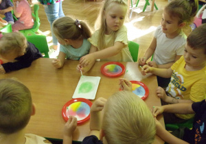 dzieci uczestniczą w eksperymencie z barwnikami spożywczymi