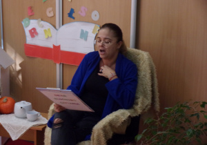 dzieci na sali gimnastycznej podczas słuchania czytanych przez pracowników przedszkola wierszy