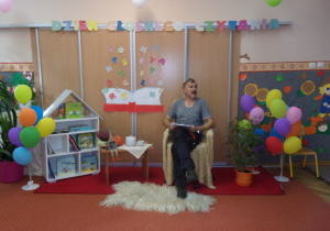dzieci na sali gimnastycznej podczas słuchania czytanych przez pracowników przedszkola wierszy