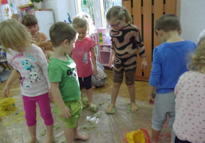 dzieci chodzą po kolorowym makaronie