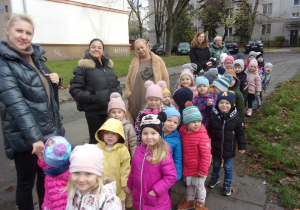 dzieci ustawione w parach w oczekiwaniu na autokar
