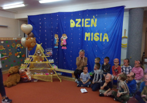 dekoracja na sali gimnastycznej z okazji Dnia Misia, obok na ławce siedzą Juniorzy