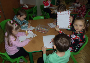 Tuptusie przy stoliczkach przygotowują listy do Mikołaja