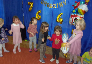 dzieci biorą udział w zabawie w przekazywanie tortu