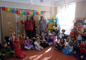 dzieci w strojach karnawałowych siedzą na dywanie