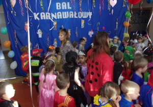 dzieci tańczą w parach na sali gimnastycznej, w tle dekoracja karnawałowa
