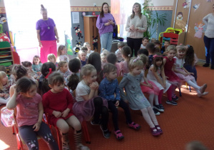 dzieci siedzą na krzesłach na sali gimnastycznej podczas jednej z zabaw na sali gimnastycznej