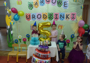 dzieci z nadmuchanym balonem w kształcie cyfry 5